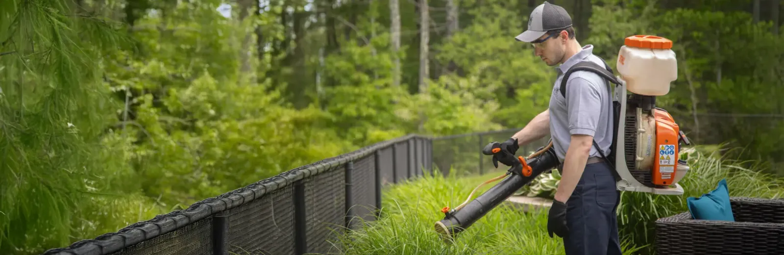Technician misting areas of property for mosquitoes