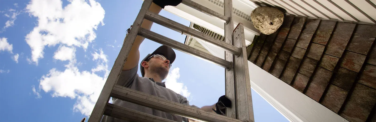pest technician inspecting outside of house