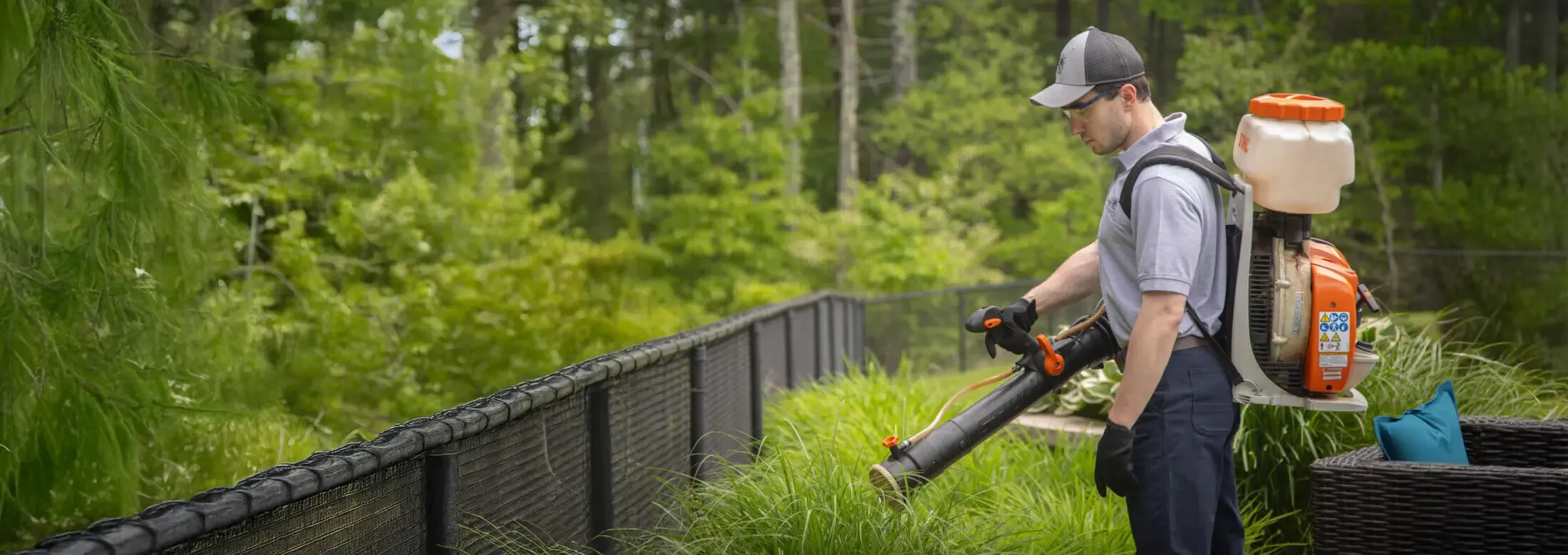 Technician misting areas of property for mosquitoes