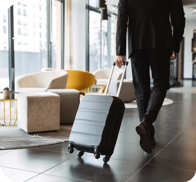 man walking with a suitcase in a hotel lobby